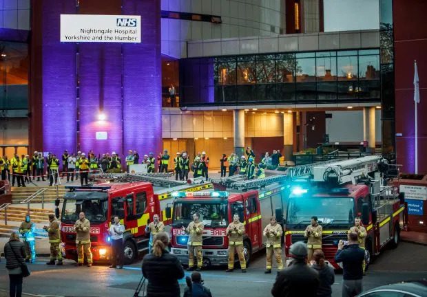 Membros da brigada de incêndio, trabalhadores da construção civil e demais cidadãos, batendo palmas do lado de fora do Hospital Nightingale, no Harrogate Convention Center. Créditos PA:Press Association