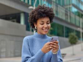 mulher feliz digitando no celular