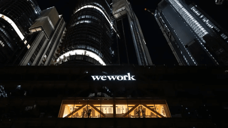 29 de julho de 2023, Austrália, Sydney: o logotipo da “Wework”, uma empresa que oferece escritórios e espaços de coworking para autônomos e empresas, ilumina o centro da cidade em frente a arranha-céus. Sebastian Christoph Gollnow | Imagem Aliança | Getty Images